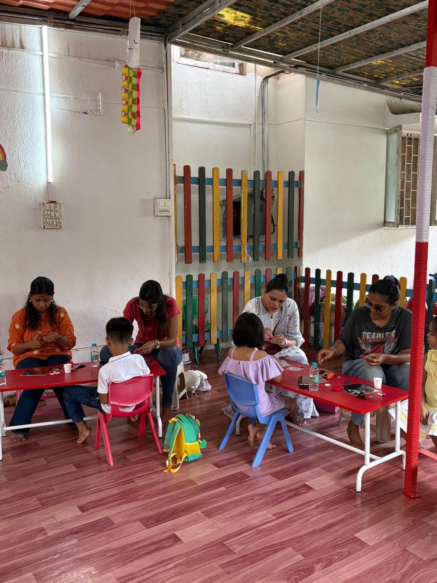 Children and parents crafting at colourful tables in the Kalashala studio